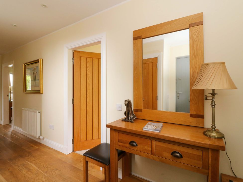 A hallway with a wooden table and mirror at Craigard in Aberfeldy