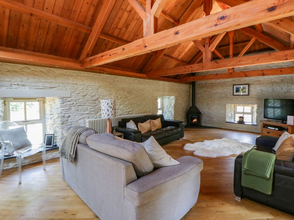 A living room with a sofa and television at Yr Hen Felin in Boncath