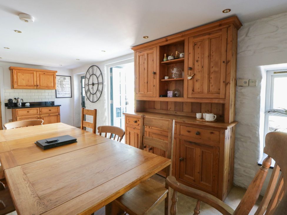A kitchen with wooden furniture and a clock at Yr Hen Felin in Boncath