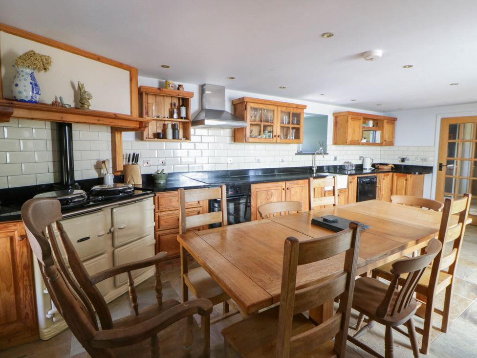 A kitchen with a dining table and chairs at Yr Hen Felin in Boncath