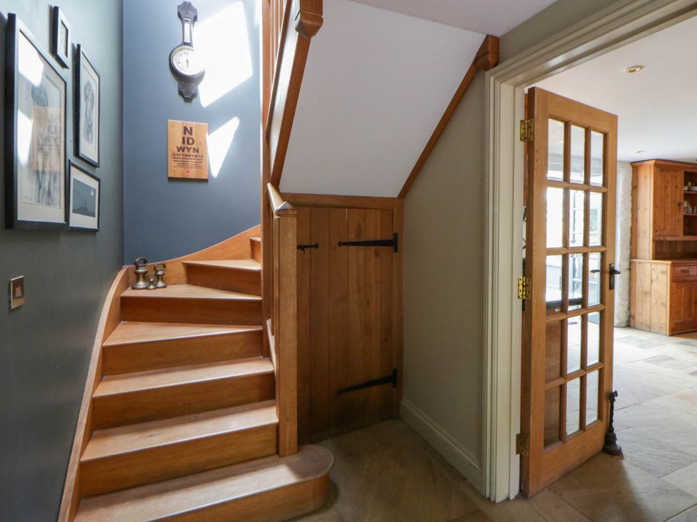 A staircase and door in a hallway at Yr Hen Felin in Boncath