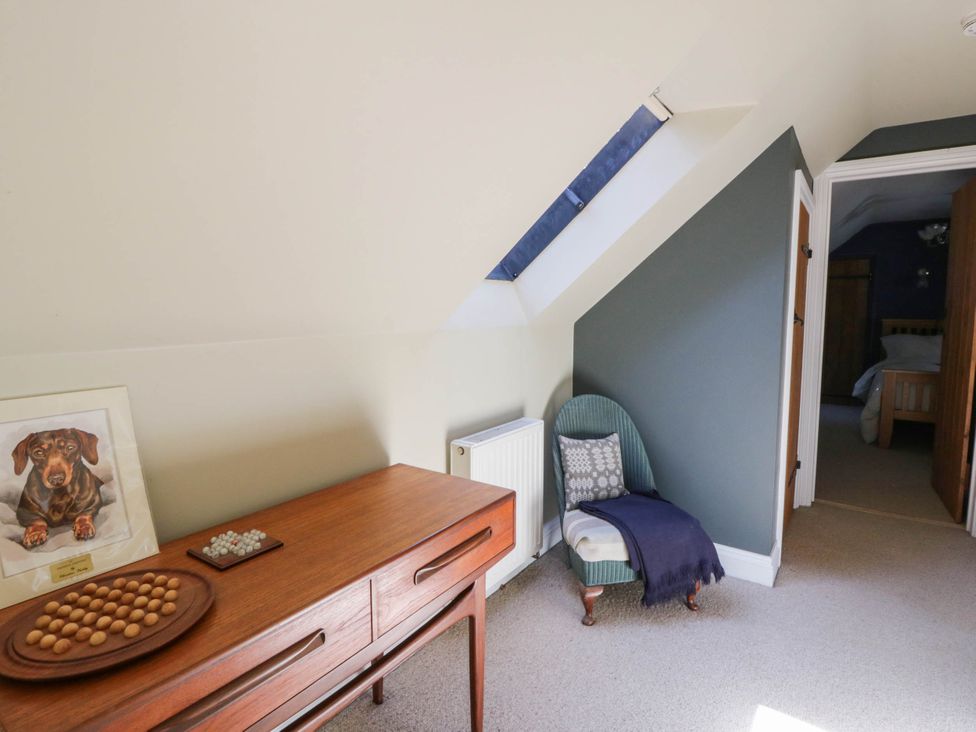 A hallway with a chair and side table at Yr Hen Felin in Boncath