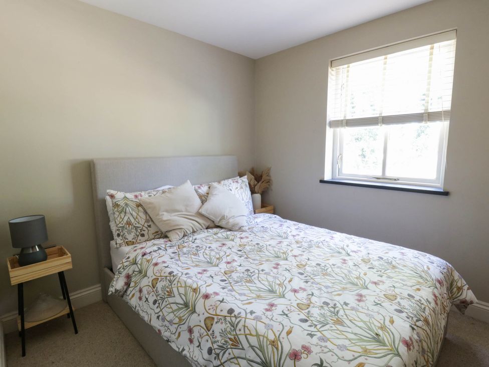 A bedroom with a bed and bedside table at Yr Hen Felin in Boncath