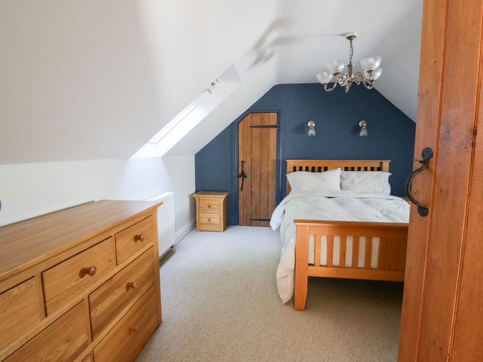A bedroom with a bed and dresser at Yr Hen Felin in Boncath