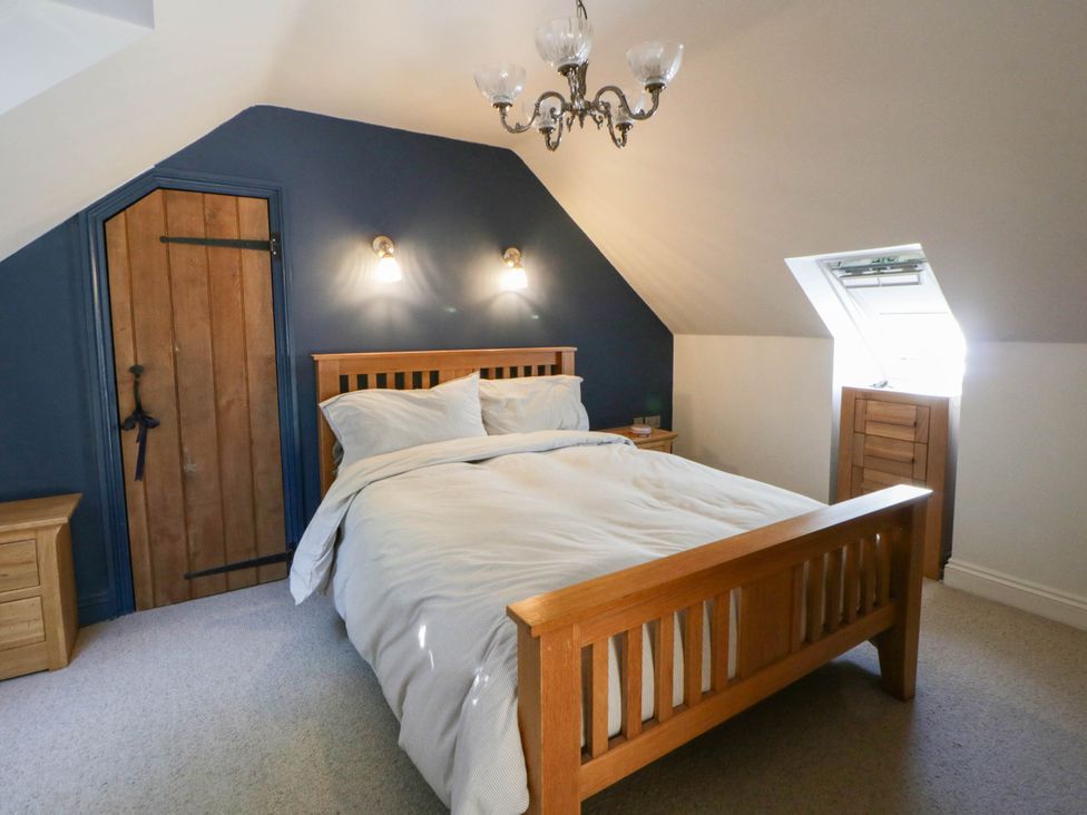 A bedroom with a bed and wooden furniture at Yr Hen Felin in Boncath