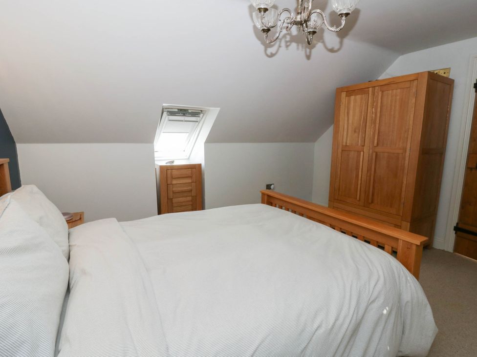 A bedroom with a bed and wardrobe at Yr Hen Felin in Boncath