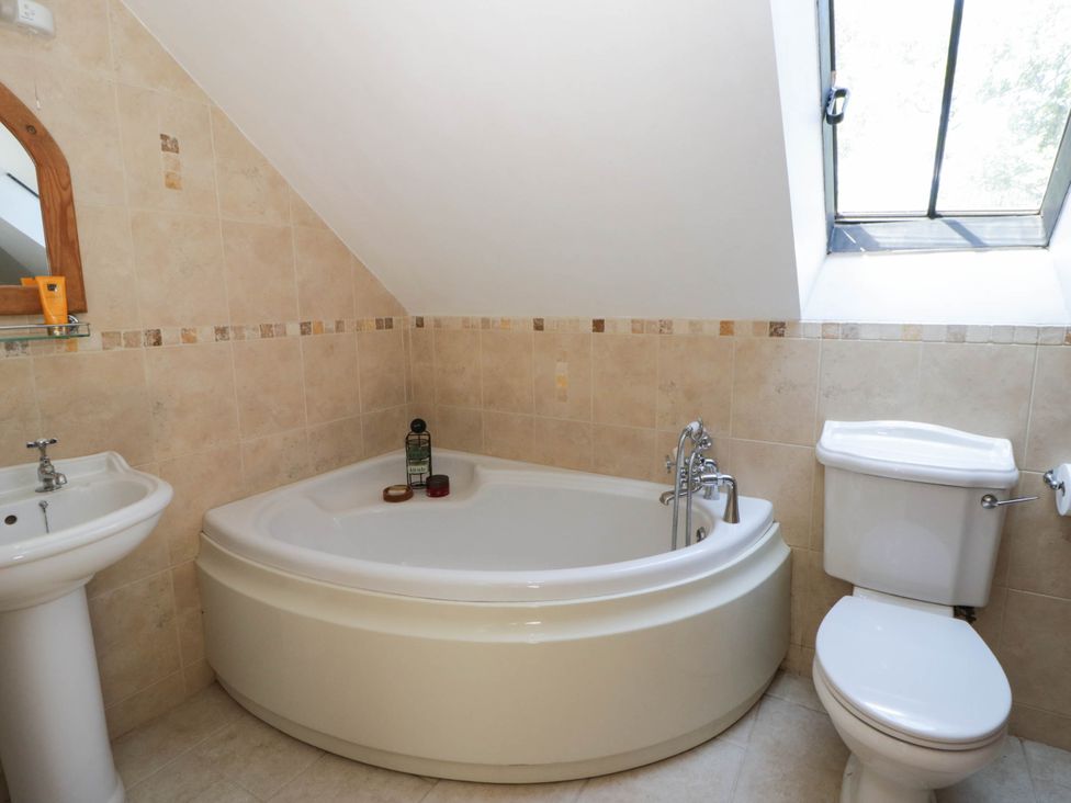 A bathroom with a bath tub, sink, and toilet at Yr Hen Felin in Boncath