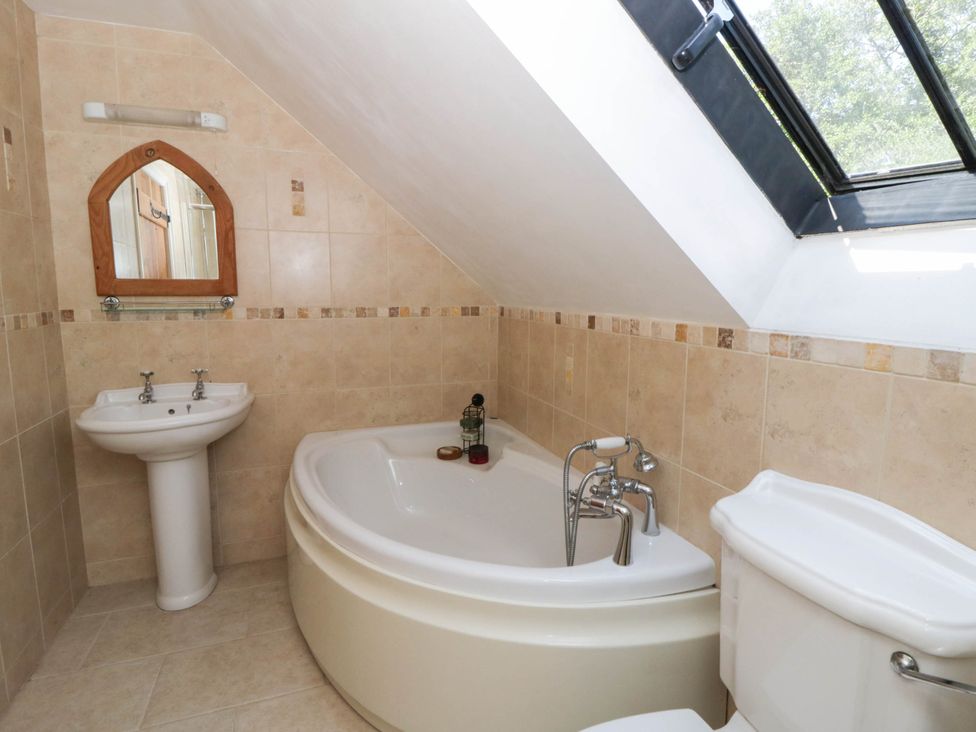 A bathroom with a bathtub, toilet, and sink at Yr Hen Felin Boncath