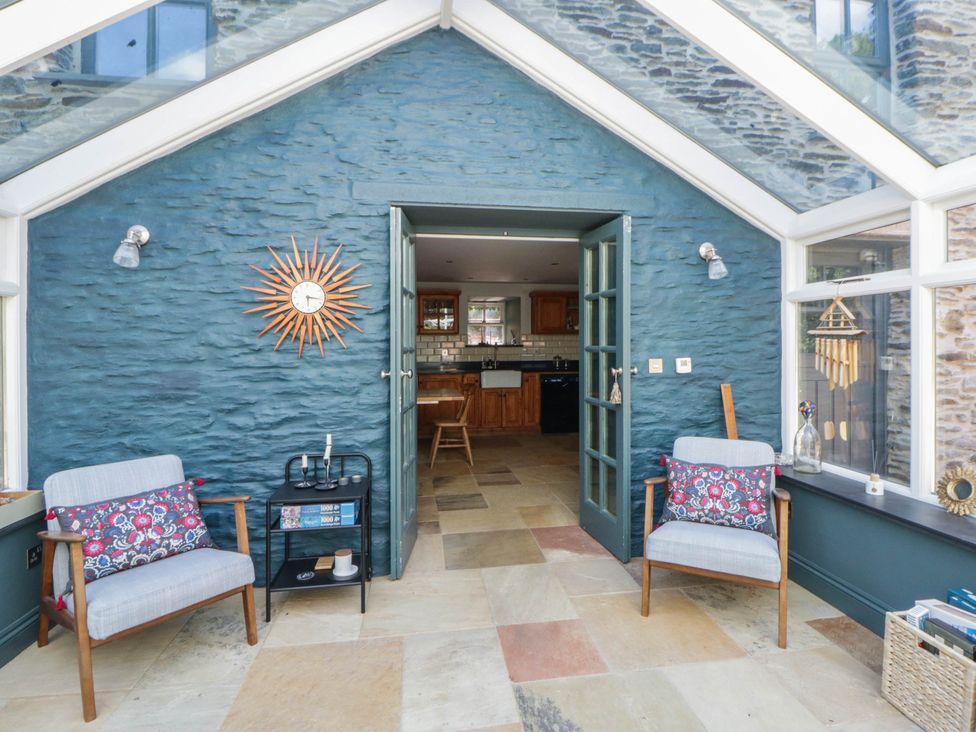 A conservatory with chairs and a table at Yr Hen Felin in Boncath