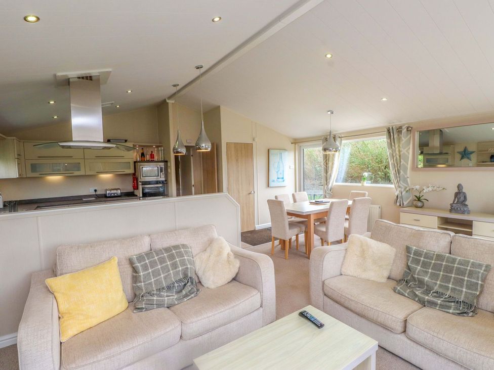 A living room with sofas and a dining area at 56 The Stables in Pwllheli