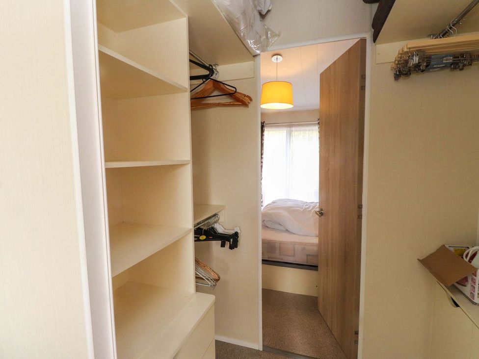 A closet with shelves and hangers in a bedroom at 56 The Stables Pwllheli