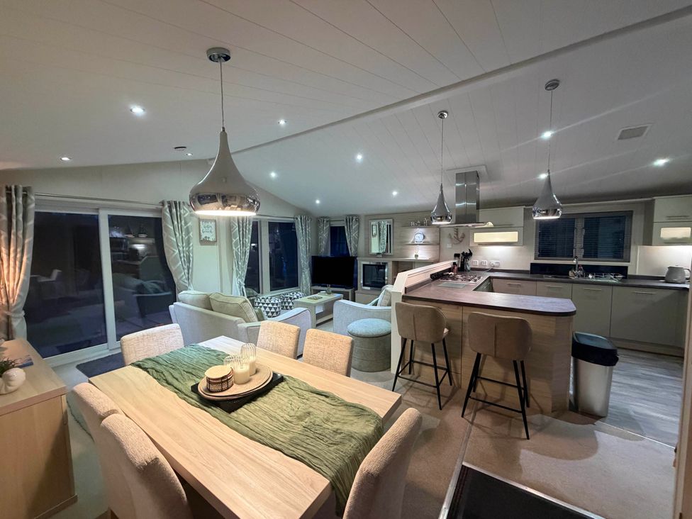 A kitchen with dining table and lounge area at The Stables in Pwllheli