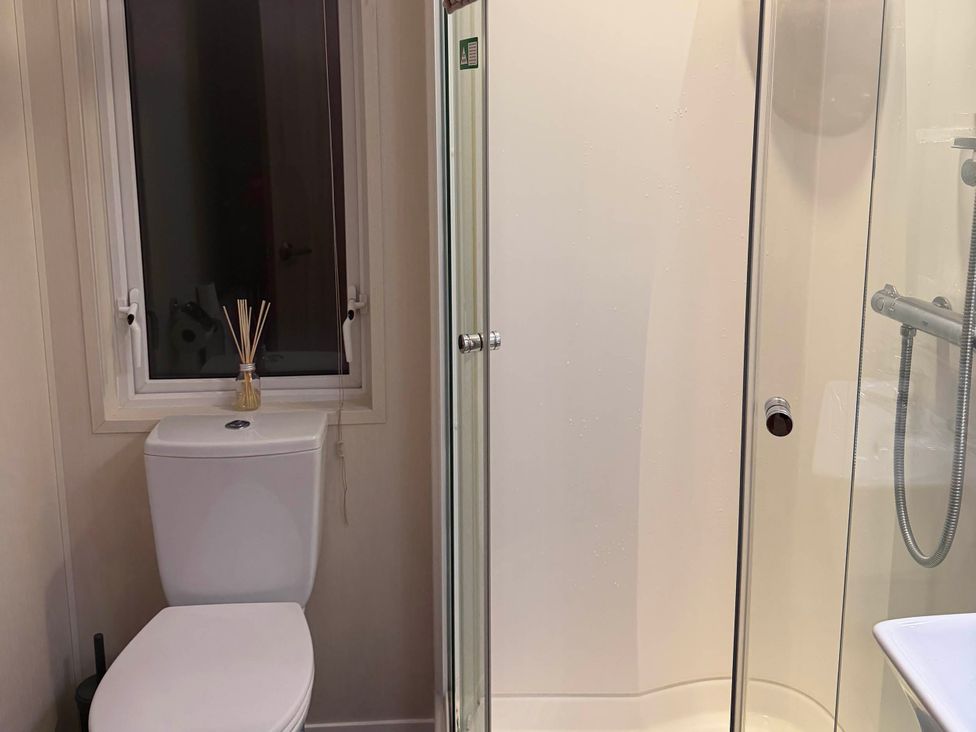 A bathroom with a toilet and a shower at The Stables in Pwllheli