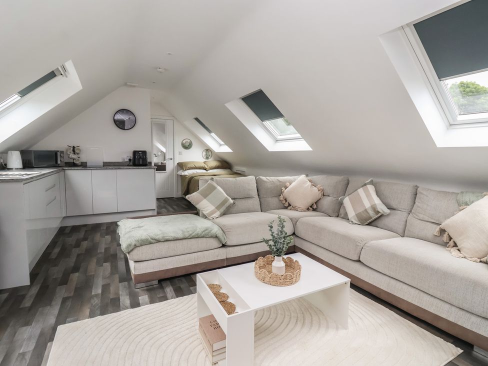 A living room with a sofa and kitchen area at Fields view in Bridlington