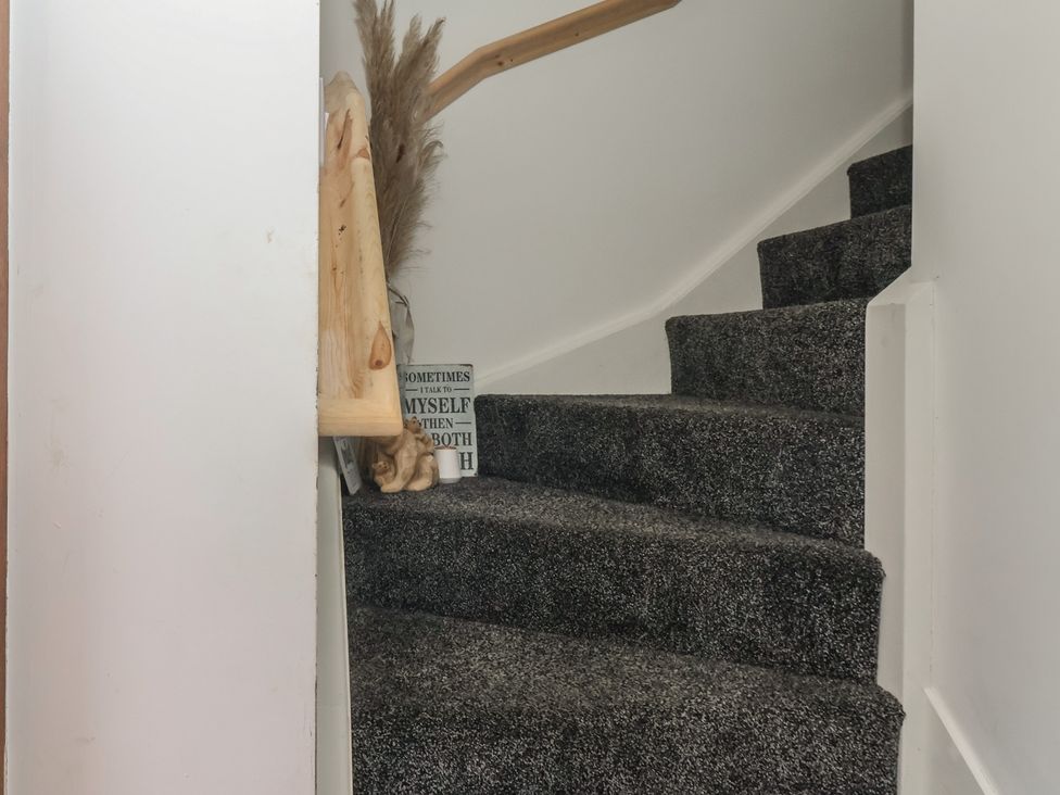A staircase with carpet and a decorative sign at Fields View in Fraisthorpe