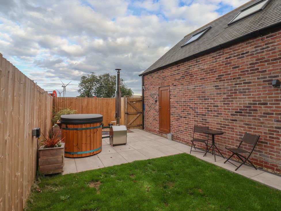 A garden with a hot tub and seating area at Fields View in Fraisthorpe