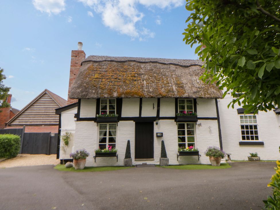 A house with a thatched roof and windows at Eightlands in Hereford