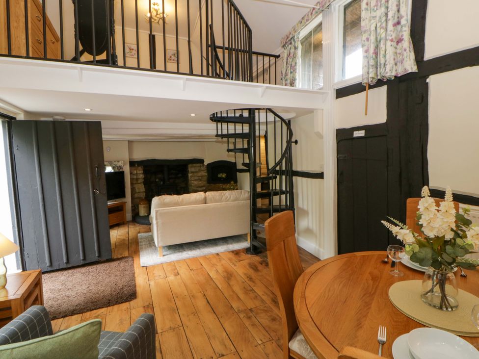 A living room with a sofa and dining table at Eightlands in Hereford