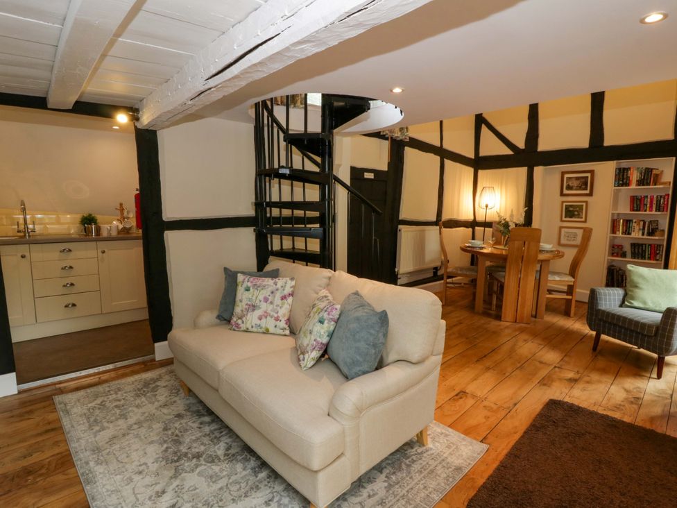 A living room with a sofa and dining area at Eightlands in Hereford