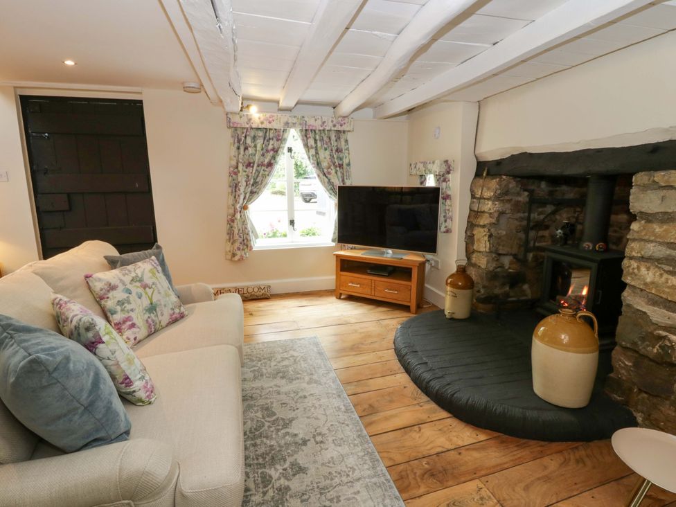 A living room with a sofa and television at Eightlands in Hereford