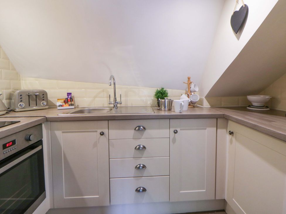 A kitchen with sink, cabinets, and appliances at Eightlands in Hereford