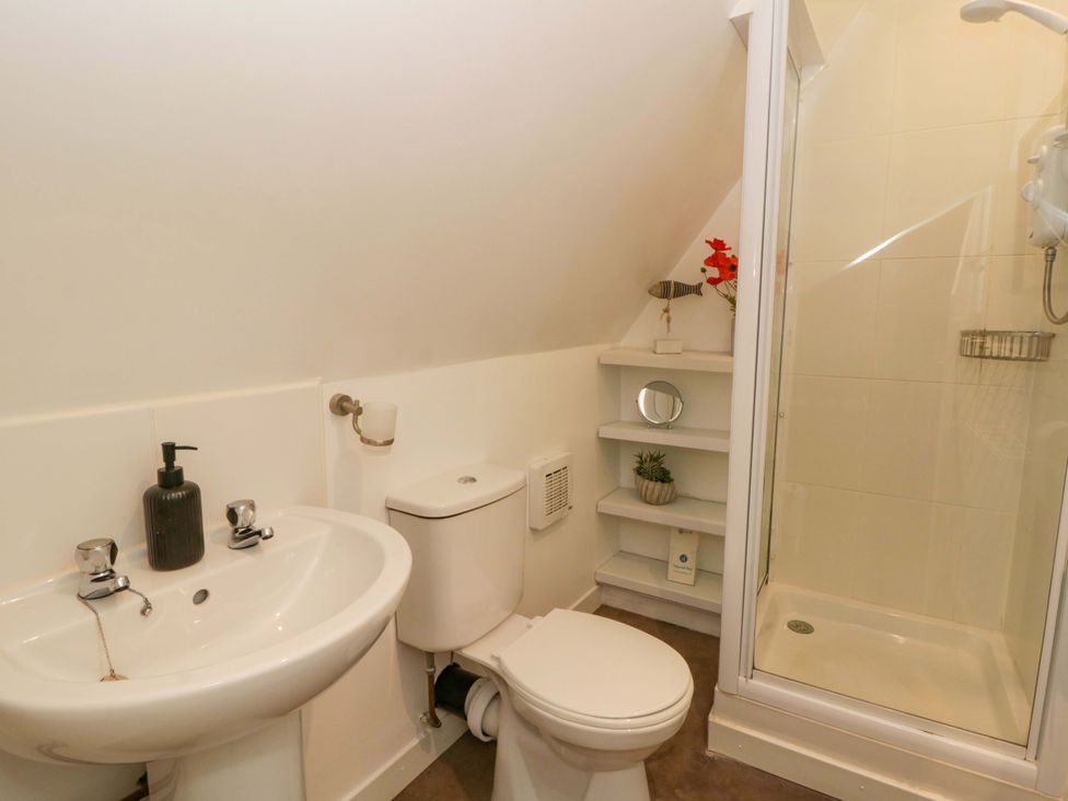 A bathroom with a sink, toilet, and shower at Eightlands in Hereford