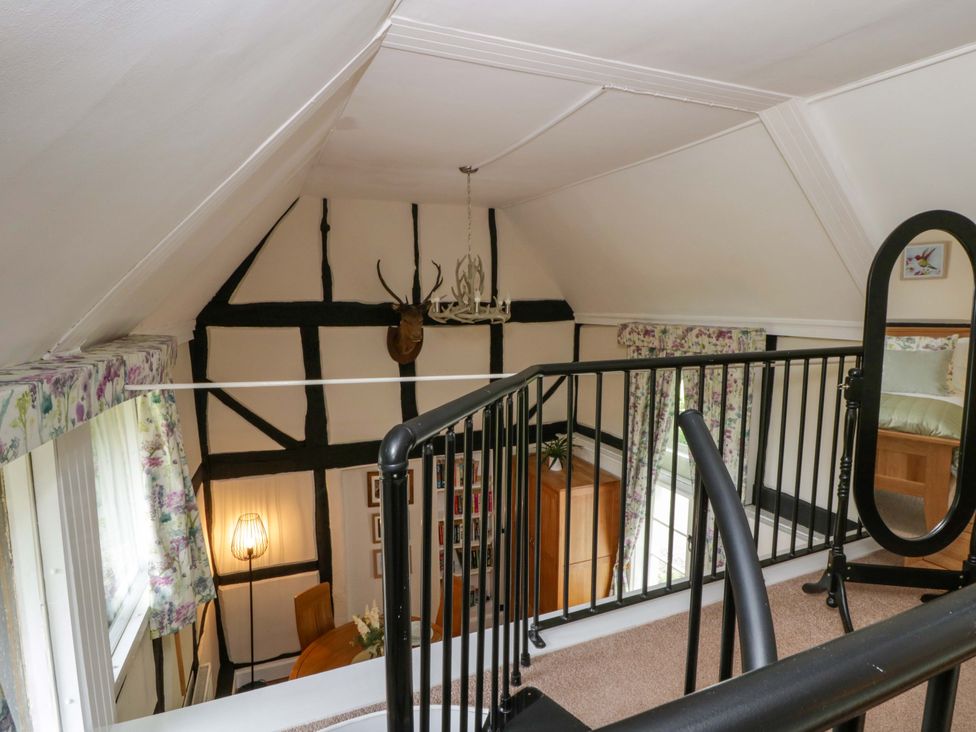 A loft with a staircase and chandelier at Eightlands in Hereford