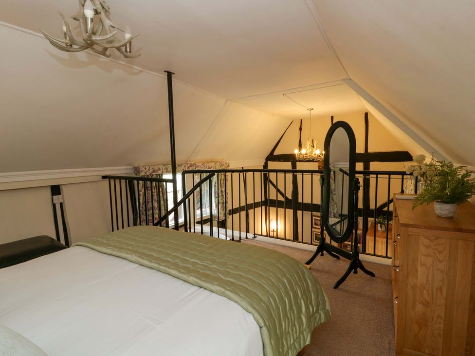 A bedroom with a bed and a mirror at Eightlands in Hereford