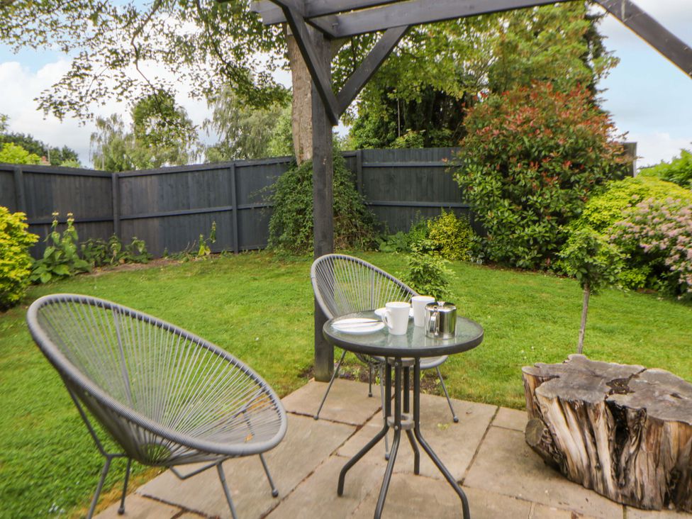 A garden scene with a table and chairs at Eightlands in Hereford