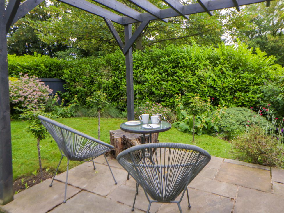 A garden with a table and chairs at Eightlands in Hereford