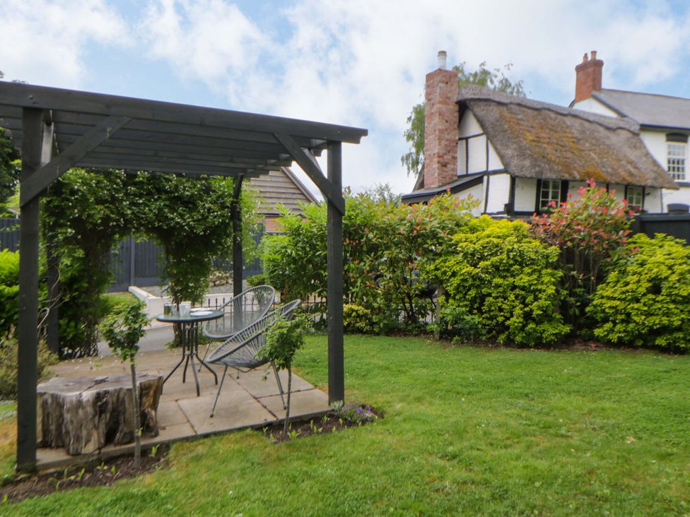 A garden with a pergola and table at Eightlands Hereford