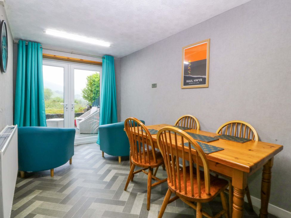 A dining room with a table and chairs at Tyr Felin in Caernarfon