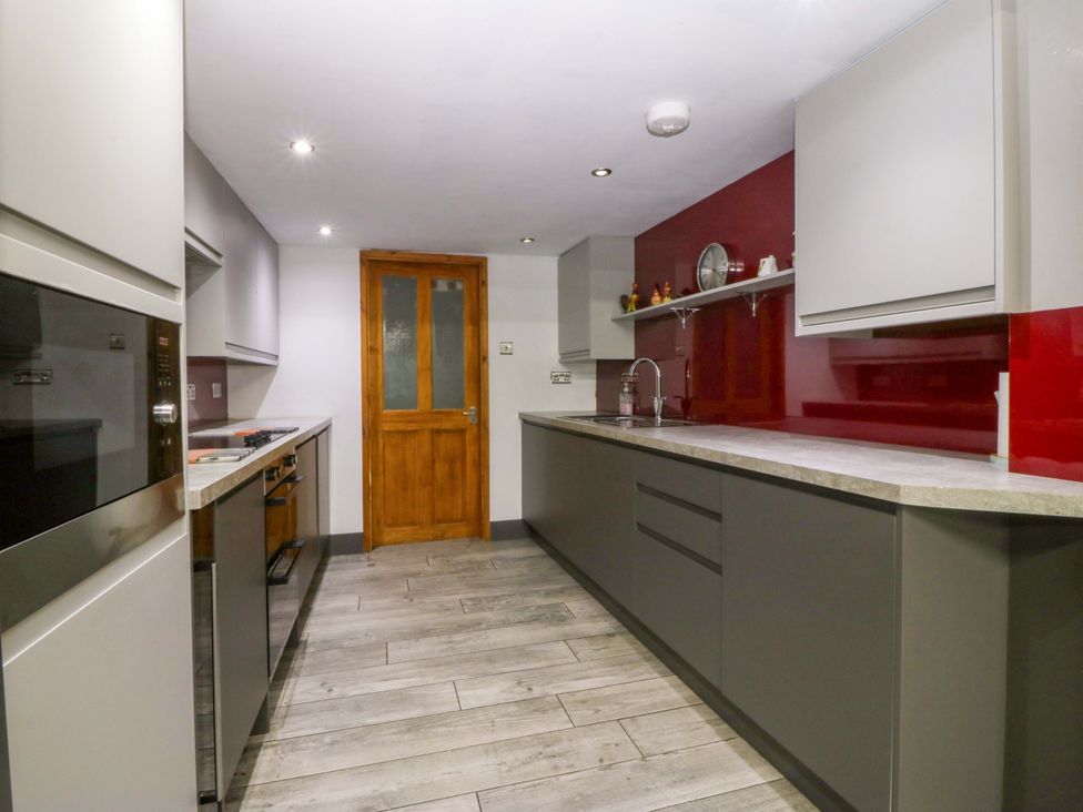 A kitchen with cabinets and appliances at Tyr Felin in Caernarfon