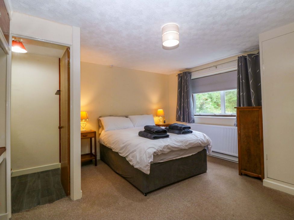 A bedroom with a bed and a lamp at Tyr Felin in Caernarfon