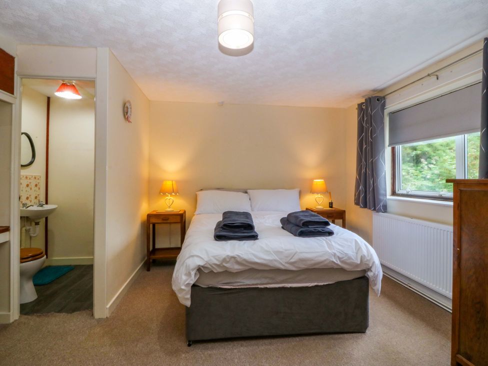 A bedroom with a bed and adjacent bathroom area at Tyr Felin in Caernarfon