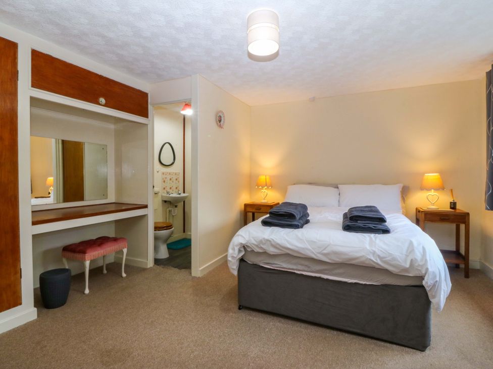 A bedroom with a bed and nightstands at Tyr Felin in Caernarfon