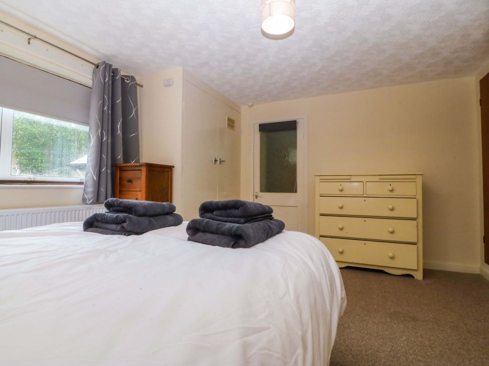 A bedroom with a bed and towels folded at Tyr Felin in Caernarfon