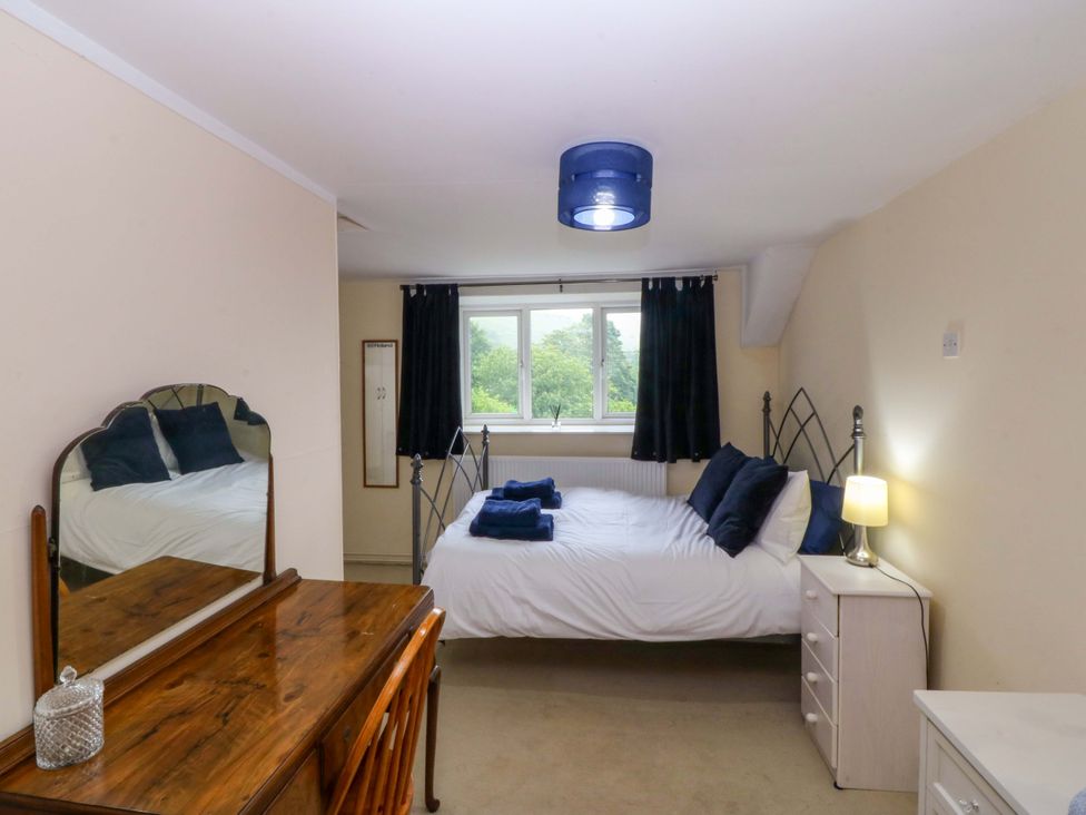 A bedroom with a bed and mirror at Tyr Felin in Caernarfon