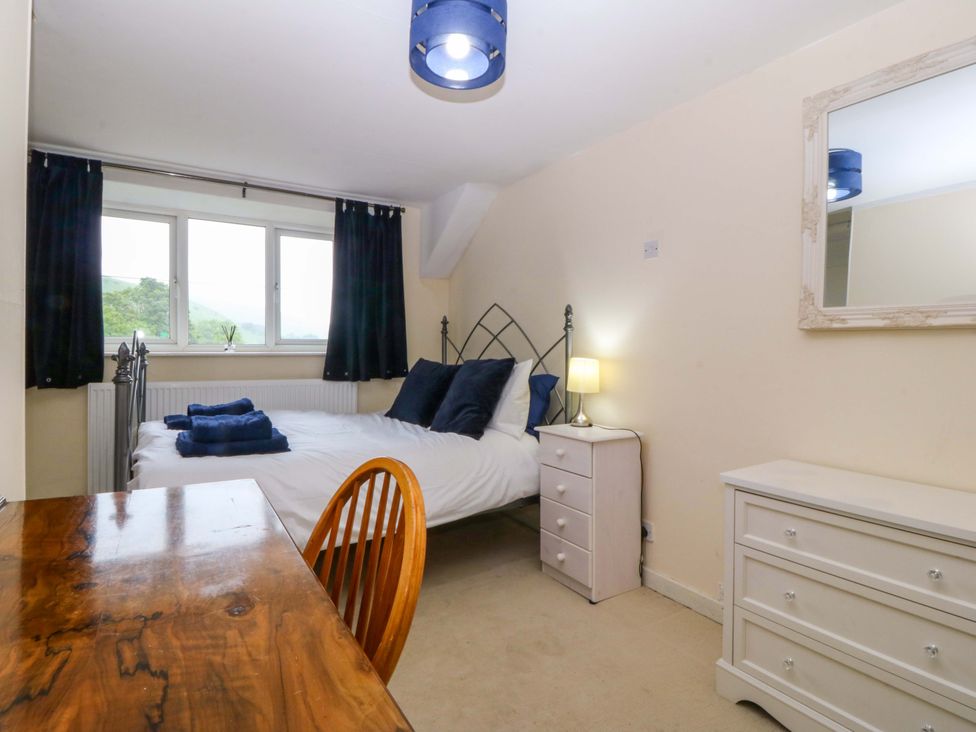 A bedroom with a bed and dresser at Tyr Felin in Caernarfon