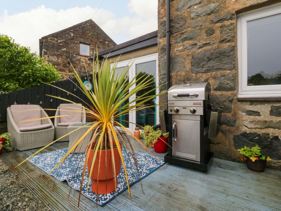 A patio area with outdoor furniture and a barbecue grill at Tyr Felin in Caernarfon