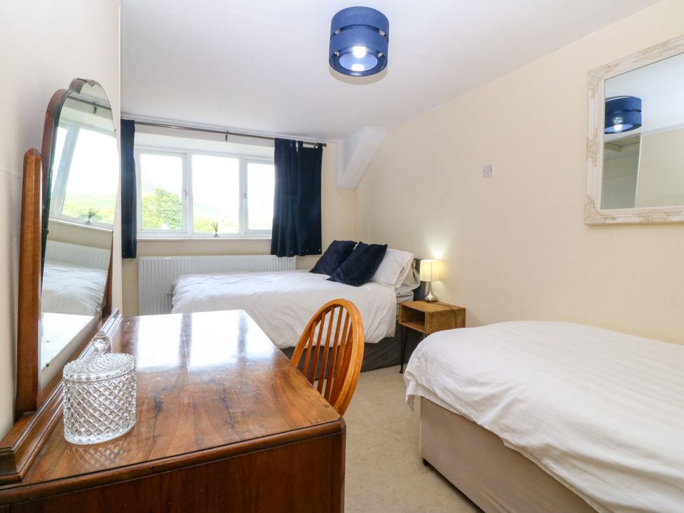 A bedroom with two beds and a table at Tyr Felin near Trefor