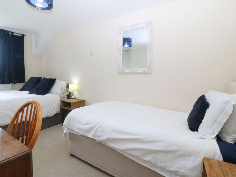 A bedroom with two beds and a table at Tyr Felin near Trefor