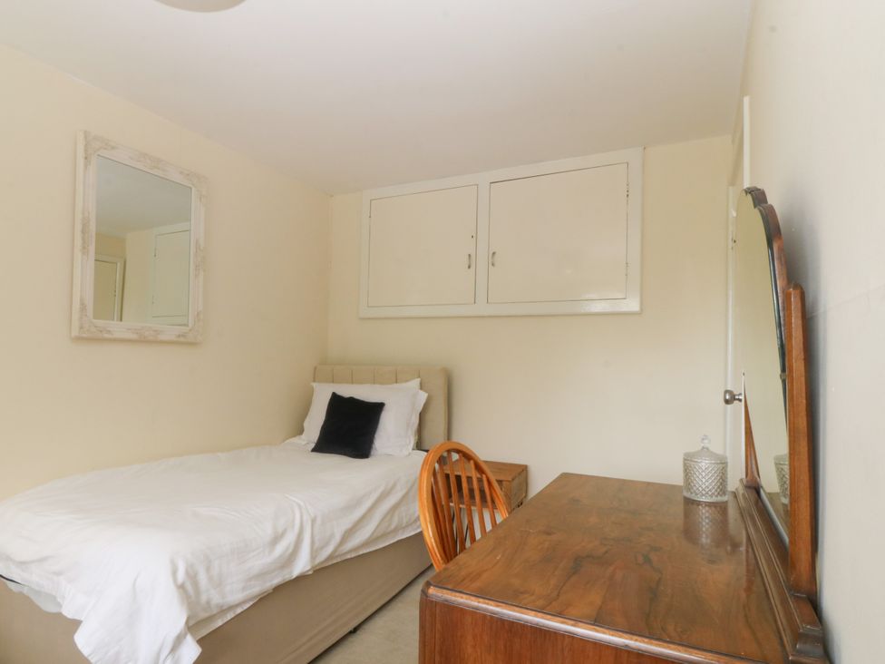 A bedroom with a bed and a desk at Tyr Felin near Trefor