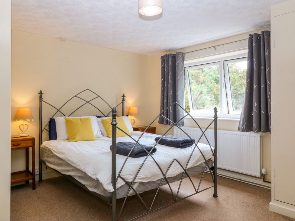 A bedroom with a bed and nightstand at Tyr Felin near Trefor