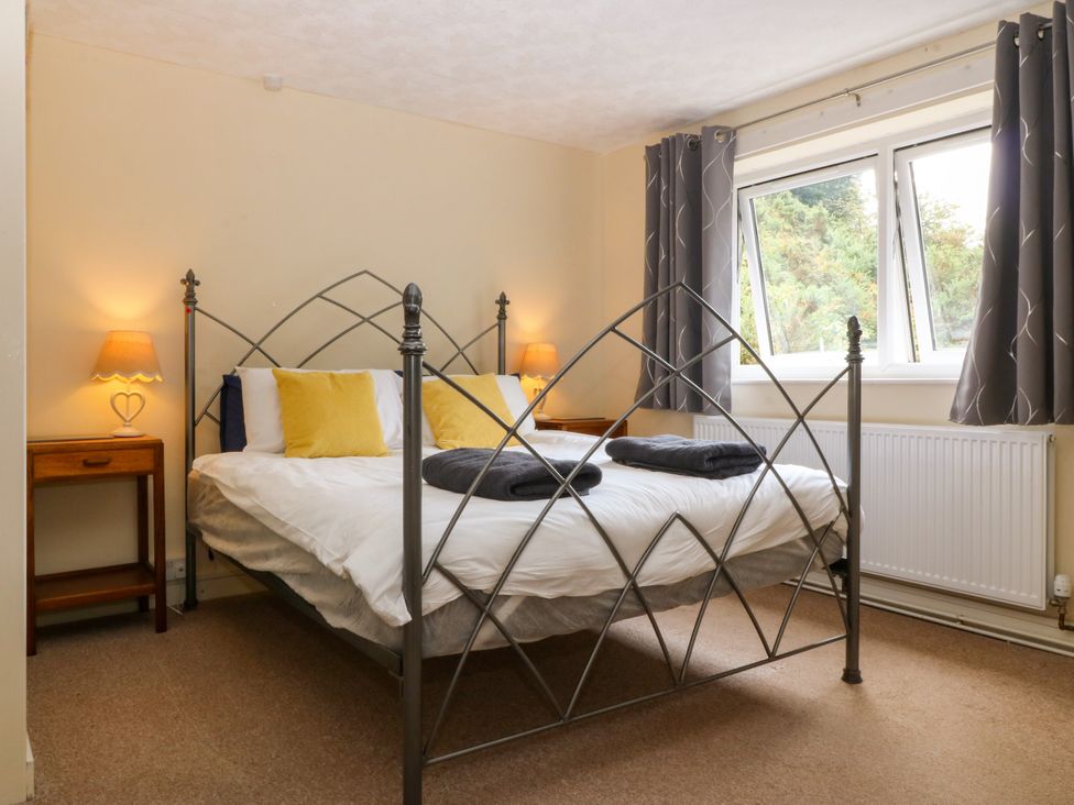 A bedroom with a bed and nightstand at Tyr Felin near Trefor