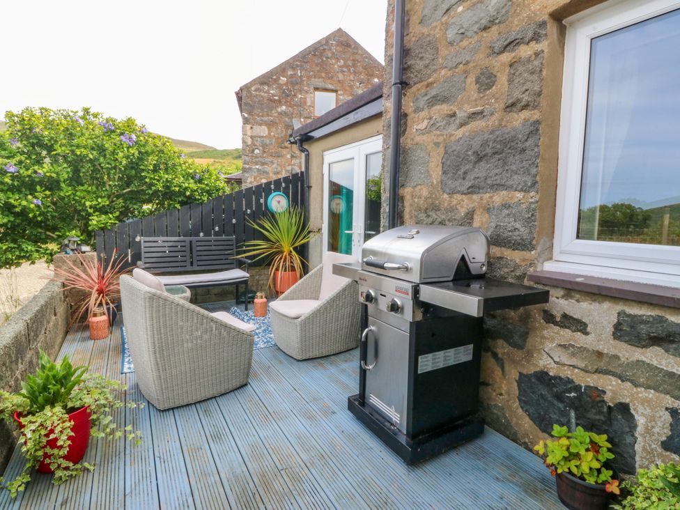 An outdoor area with seating and a grill at Tyr Felin near Trefor