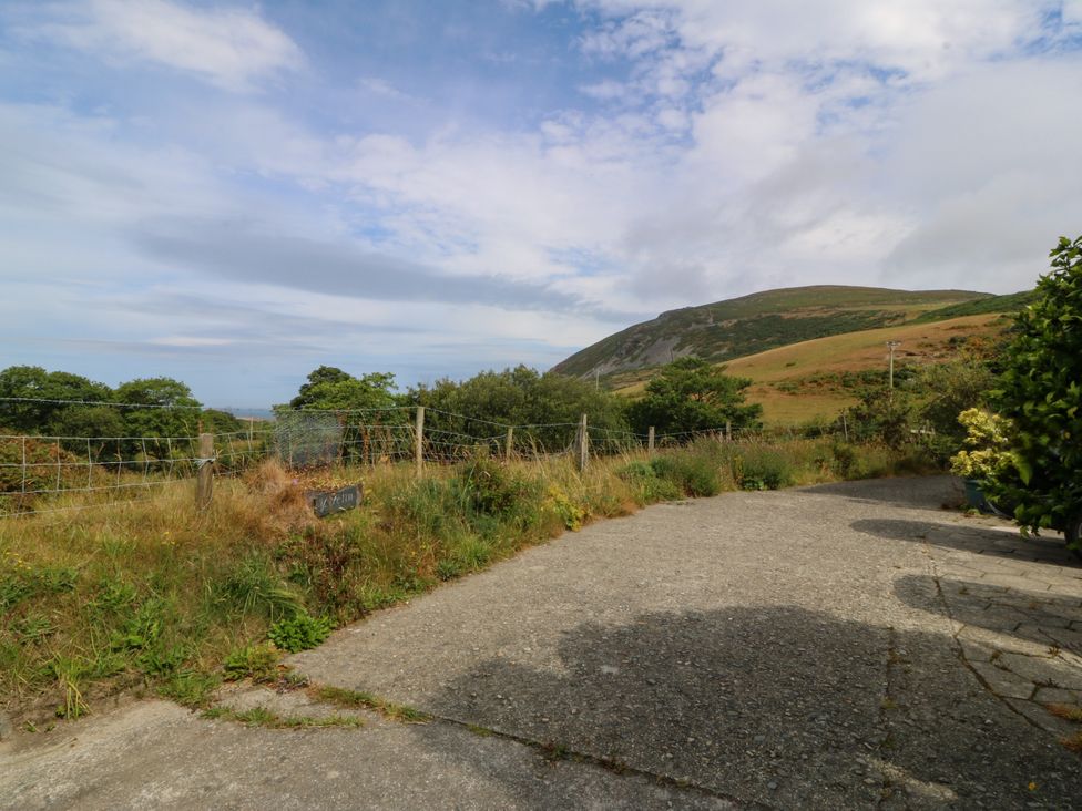 An outdoor area with a concrete path and views of a hill at Tyr Felin near Trefor
