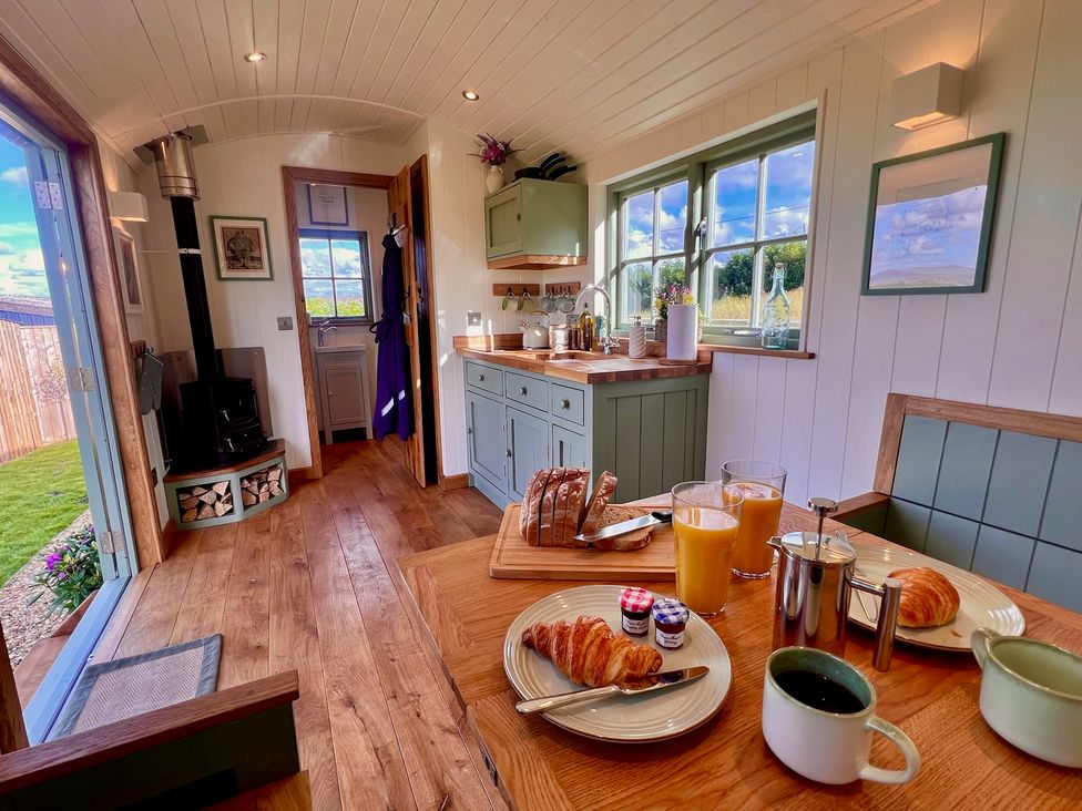 A kitchen with a breakfast setup including bread and drinks at Olive Hut