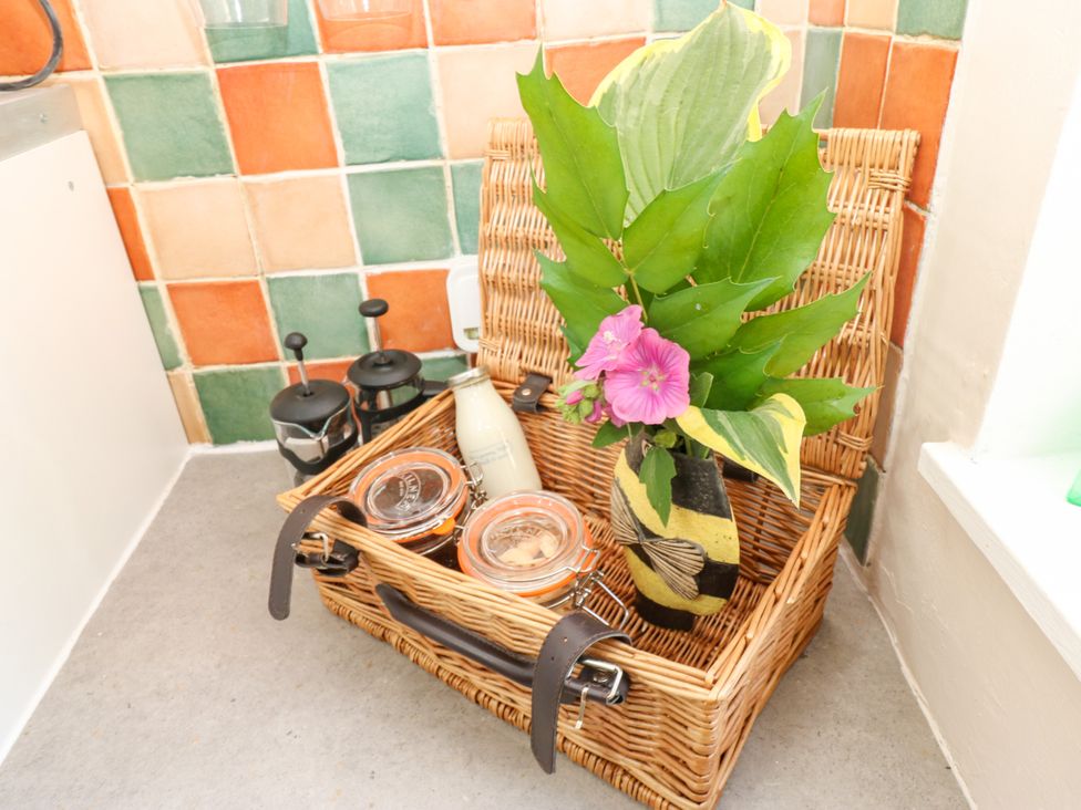 A basket with flowers and jars in the kitchen at Arch Mews Cottage Middleton-In-Teesdale