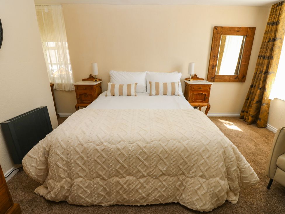 A bedroom with a bed and nightstands at Arch Mews Cottage Middleton-In-Teesdale